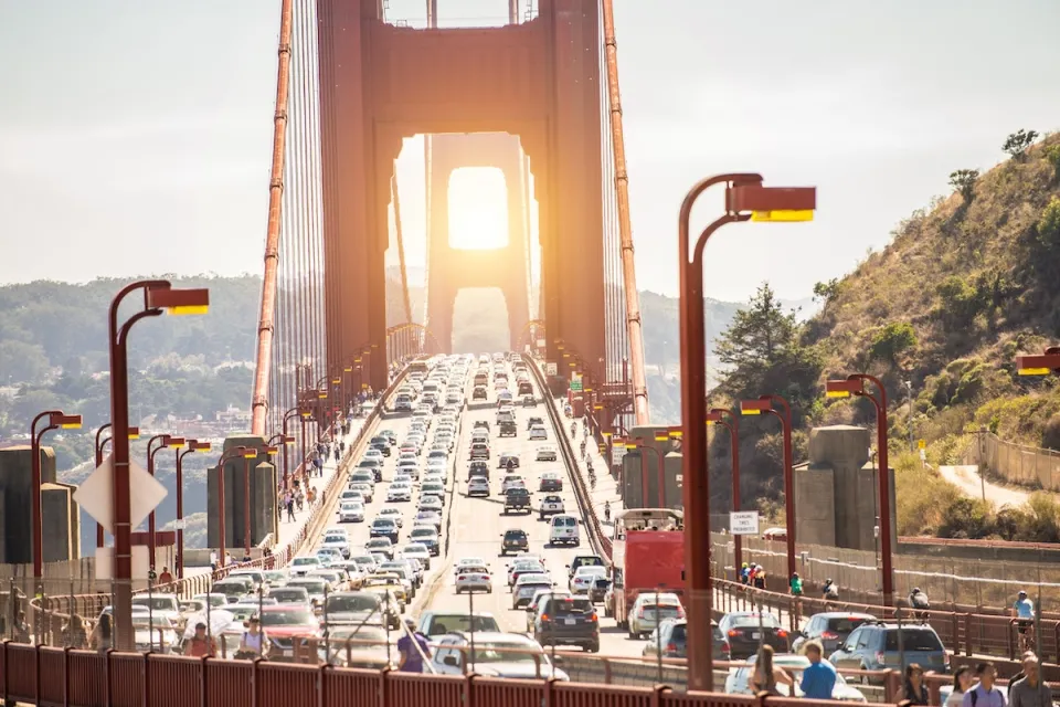 View of traffic on Golden Gate Bridge at sunset.
